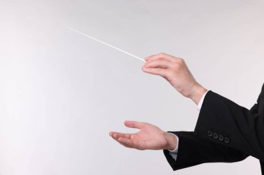 Açık gri arka planda copu olan kondüktör, yakın plan. Metin için boşluk