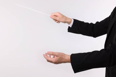 Açık gri arka planda copu olan kondüktör, yakın plan. Metin için boşluk