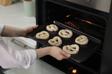 Pişmemiş krakerlerle fırına yemek koyan kadın, yakın plan.