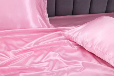 Yatakta lüks ipek çarşaflar, yakın çekim manzarası.