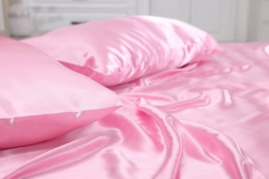 Lüks ipek çarşaflar evdeki yatakta, yakın plan.