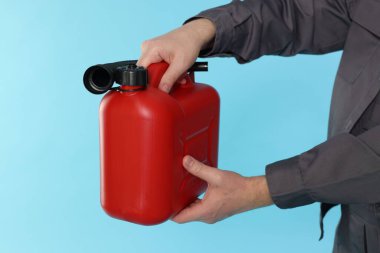 Açık mavi arka planda plastik kutu tutan adam, yakın plan.