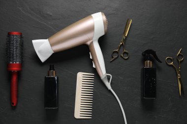 Siyah desenli arka planda farklı saç şekillendirme araçları, düz yatış