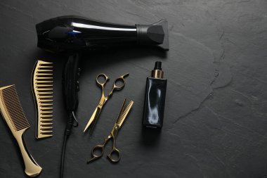 Siyah desenli arka planda farklı saç şekillendirme araçları, düz yatış. Metin için boşluk