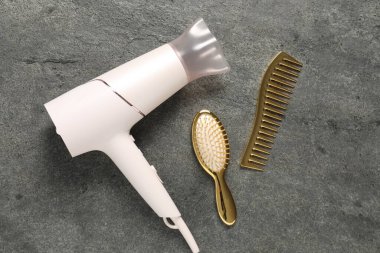 Gri dokulu arka planda farklı saç şekillendirme araçları, düz yatış