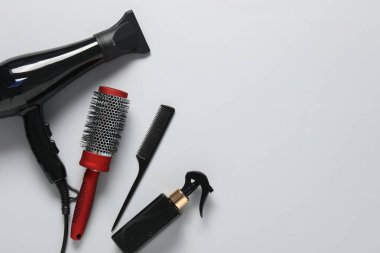 Beyaz arka planda farklı saç şekillendirme araçları, düz yatış. Metin için boşluk