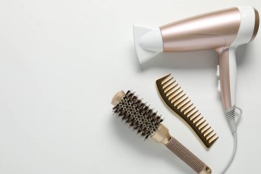 Beyaz arka planda farklı saç şekillendirme araçları, düz yatış. Metin için boşluk
