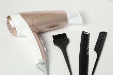 Beyaz arkaplanda farklı saç şekillendirme araçları, yakın plan