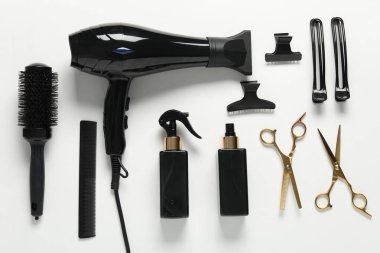 Beyaz arka planda farklı saç şekillendirme araçları, düz yatış