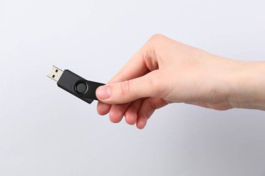 Açık gri arka planda modern flash diski olan adam, yakın plan.