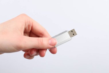 Açık gri arka planda modern flash diski olan adam, yakın plan.