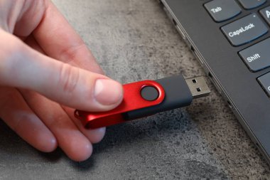 Adam modern flash belleği gri masaya yerleştiriyor, yakın plan.