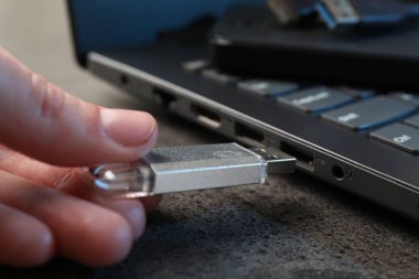 Adam modern flash belleği gri masaya yerleştiriyor, yakın plan.