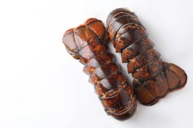 Çiğ ıstakoz kuyrukları beyaz masada, düz yerde. Metin için boşluk