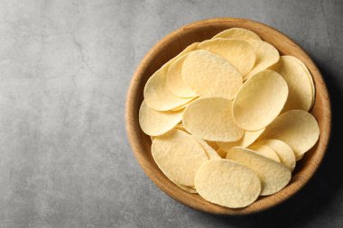 Gri masada leziz patates cipsleri, üst manzara. Metin için boşluk