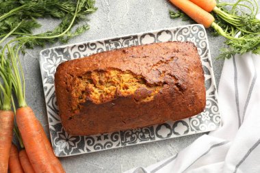 Lezzetli havuçlu kek ve sebzeler gri desenli masada, düz yatıyordu.