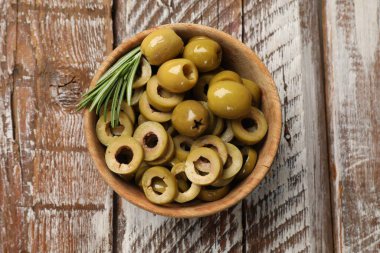 Lezzetli salamura edilmiş zeytin halkaları, biberiye ve ahşap masadaki bütün halkalar.