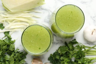 Sağlıklı maydanozlu smoothie, sarımsak, lahana ve yapraklar beyaz mermer masada, düz yatıyordu.