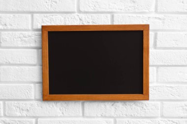 Beyaz tuğla duvarda boş bir karatahta