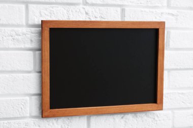 Beyaz tuğla duvarda boş bir karatahta