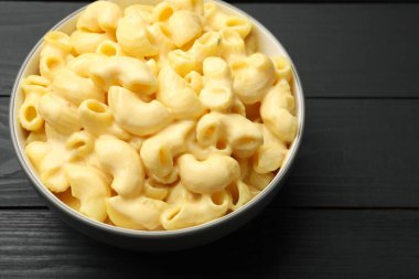 Lezzetli makarna ve peynir siyah ahşap masada, yakın plan.