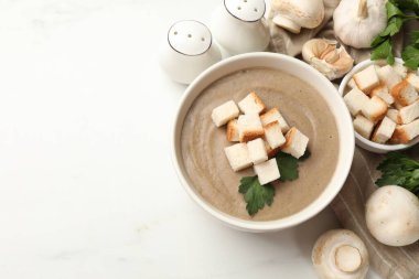 Ekmek arası mantar kremalı çorba, maydanoz ve malzemeler beyaz masada. Metin için boşluk