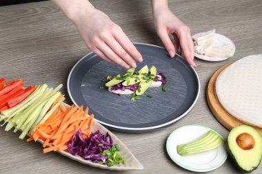 Gri ahşap masada nefis börek yapan kadın, yakın plan.