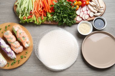 Pirinç kağıt çarşaflar ve gri ahşap masa üzerindeki farklı malzemeler.