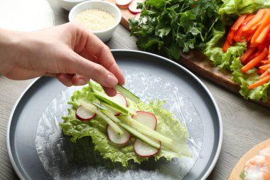 Gri ahşap masada nefis börek yapan kadın, yakın plan.