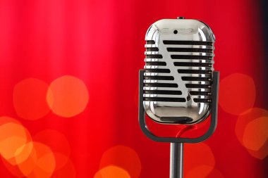 Kırmızı arkaplana karşı bir klasik mikrofon, mesaj için boşluk. Bokeh etkisi