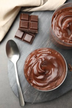 Lezzetli puding ve çikolata parçaları gri masada, düz yatıyordu.