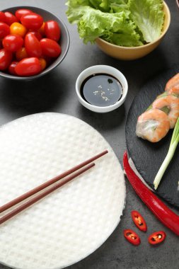 Pilav kağıtları ve farklı malzemeler koyu gri masada, üst tarafta.