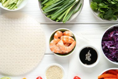 Pirinç kağıt çarşaflar ve beyaz ahşap masa üzerindeki farklı malzemeler.