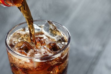 Tazeleyici kolayı bulanık gri arka planda cama döküyorum. Yakın plan. Metin için boşluk