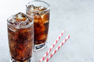 Kola bardaklarda buz ve ışık masasında pipet ile tazeleniyor. Metin için boşluk