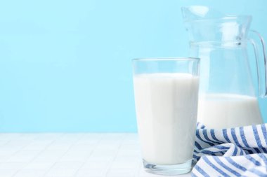 Açık mavi arka planda beyaz masada taze süt. Metin için boşluk