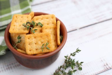 Beyaz ahşap masaya kekik konmuş lezzetli tuzlu krakerler, yakın plan. Metin için boşluk