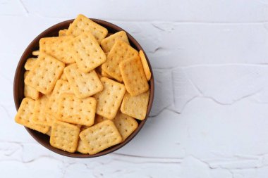 Beyaz desenli masada leziz tuzlu krakerler, üst manzara. Metin için boşluk