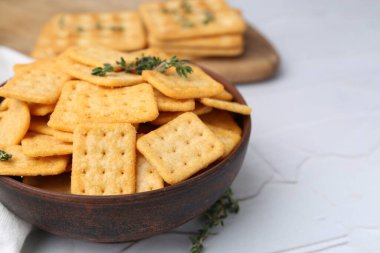 Lezzetli tuzlu krakerler ve kekik beyaz desenli masa, yakın plan.