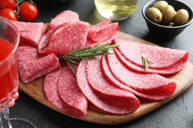 Siyah masada servis edilen biberiyeli lezzetli sosis dilimleri, yakın plan.