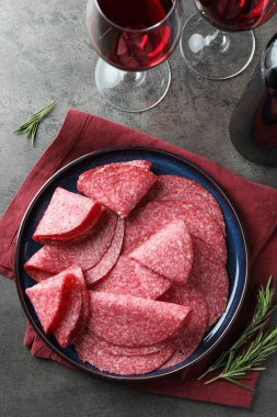 Gri masada servis edilen leziz sosis dilimleri.