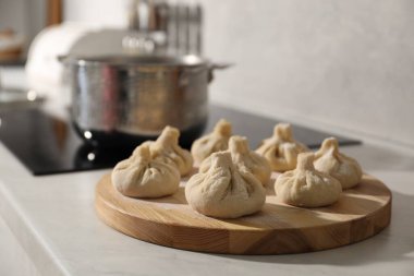 Mutfak tezgahında tencereli ve pişmemiş khinkali, seçici odak