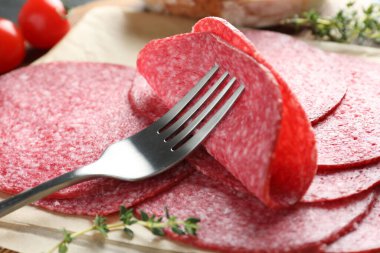 Lezzetli füme sosis, kekik ve çatal masada, yakın plan.