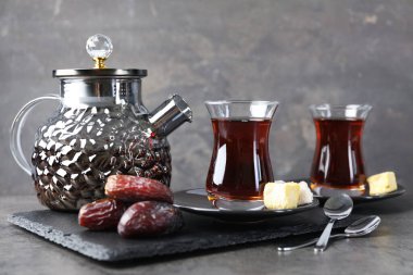 Gri masadaki şekerlerle servis edilen lezzetli Türk çayı.