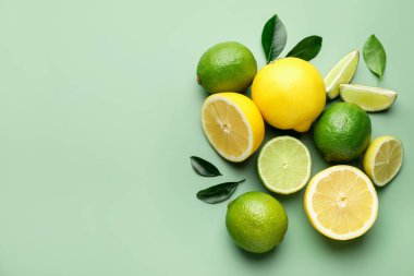 Taze limon ve limon soluk yeşil arka planda, düz yerde. Metin için boşluk