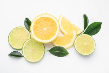 Beyaz arka planda taze limon, limon ve yapraklar var.