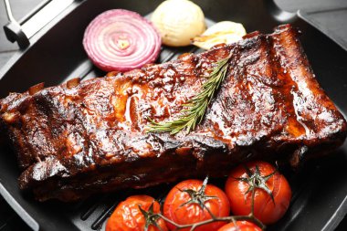 Biberiyeli domuz pirzolası, domates ve soğan. Gri ahşap masada, yakın plan.