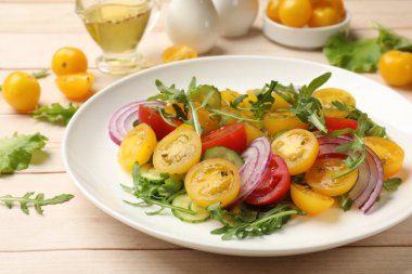 Beyaz ahşap masada sarı domatesli taze salata, yakın plan.