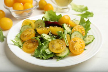 Beyaz masada sarı domatesli taze salata, yakın plan.