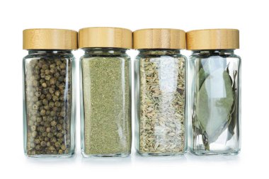 Beyaz kavanozlardaki farklı aromatik baharatlar.